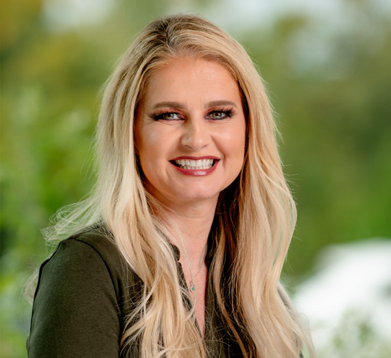 밝게 조명된 병원 복도에 다섯 명의 사람들이 함께 서서 카메라를 바라보며 웃고 있습니다. 두 명은 청진기와 의료복을 입었고, 한 명은 곤자가 대학교 스웨터를 입었으며, 나머지 사람들은 캐주얼하거나 전문적인 복장을 입고 있어 학생들과 의료 전문가들이 혼합된 모습을 보여줍니다.